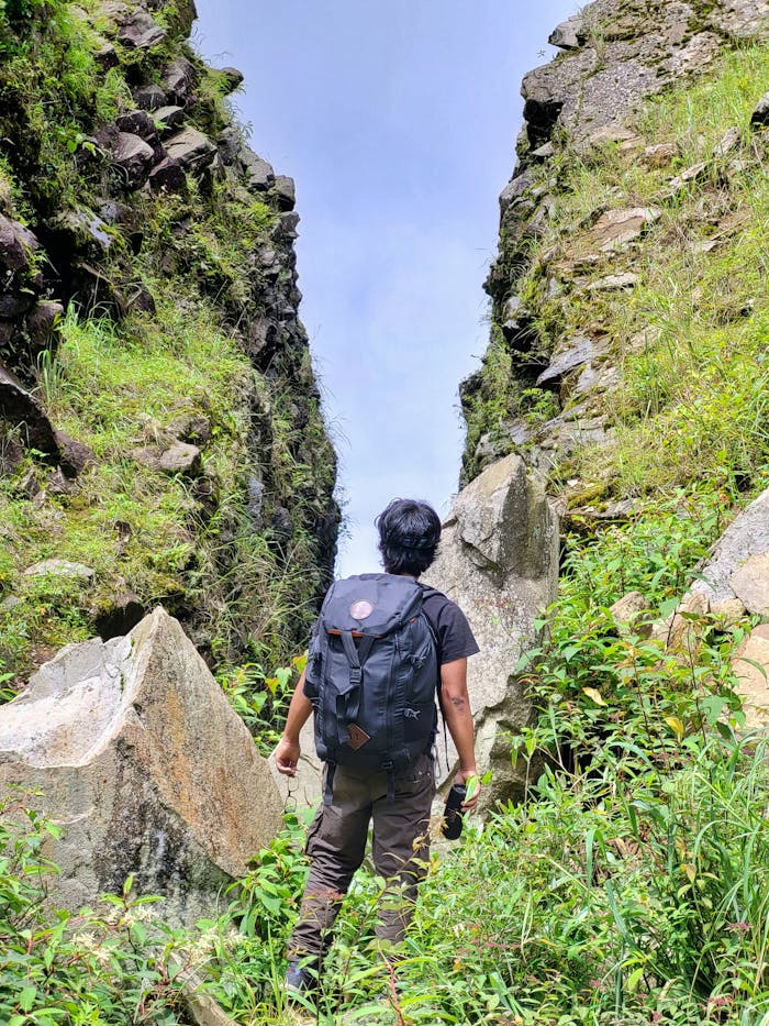 Les plus belles destinations à découvrir à Madagascar A solo trekker explores the rocky pathways of Dzukou Valley, Nagaland, India, surrounded by lush greenery.